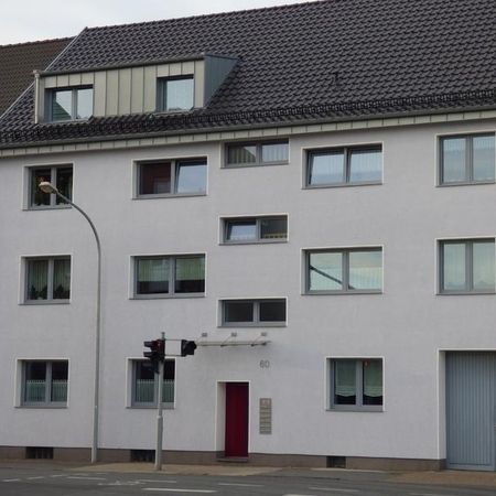 Dreistöckiges Gebäude mit einer roten Tür und einer Straßenlaterne an der Vorderseite